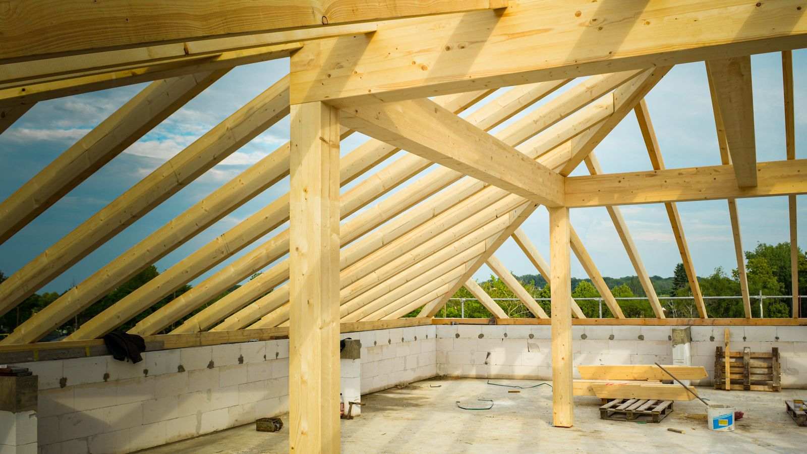 Wooden roof framing of a house under construction, seen from inside the block walls